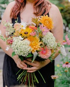 a woman holding a bouquet of flowers in her hands