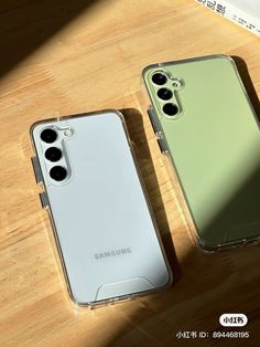 two cases sitting on top of a wooden table next to each other, one green and the other white