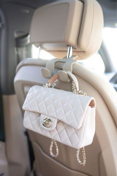 a white purse hanging from the back seat of a car