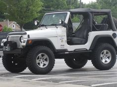 a white jeep parked in a parking lot