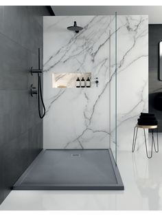 a bathroom with marble walls and flooring, including a walk in shower that has an overhead faucet