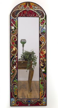 a decorative mirror with a potted plant in it