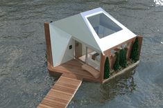 a house floating on top of water next to a dock