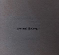 the words you smell like love are written in black ink on a gray sheet of paper