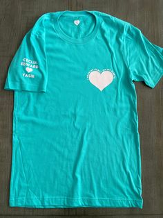 Unisex adult t-shirt in 100% soft cotton. Heart with I wear my heart on my sleeve around it on left side of chest. Names and heart on right sleeve. Don't see a color you want as an option? Reach out to us and we will be sure to try our best and fulfil your request. Live chat us directly on our site, dm us on Instagram, email us at cheeksandbubbles@gmail.com THIS ITEM GETS FREE ECONOMY SHIPPING! Care instructions - For best results wash inside out in cold water and tumble dry low. Wear My Heart On My Sleeve Shirt, Blue Short Sleeve Tops With Heart Graphic, Blue Crew Neck Tops With Heart Graphic, Blue Cotton Tops With Heart Graphic, Blue Crew Neck Top With Heart Graphic, Blue Graphic Tee With Heart Graphic, Green Crew Neck T-shirt With Heart Graphic, Pre-shrunk Short Sleeve T-shirt For Awareness Events, Heart-shaped Graphic Tee With Screen Print