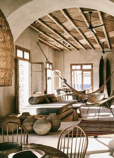 a living room with hammock chairs and tables