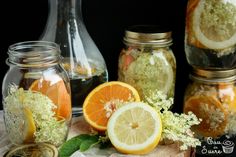 some oranges and lemons are in glass jars on a table with other items