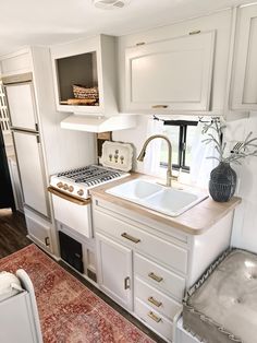 a kitchen with white cabinets and an area rug