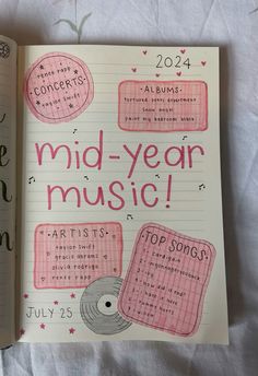 an open notebook with the words mid - year music written in pink and black on it