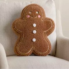 a stuffed ginger sitting on top of a white chair next to a pillow with pink eyes