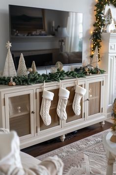 a living room with christmas stockings hanging on the wall and a television in the background