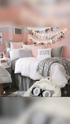 a bedroom decorated in pink, grey and white with pictures on the wall above the bed