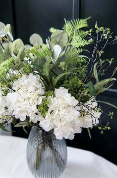 a vase filled with white flowers on top of a table