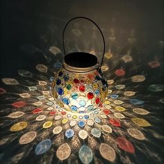 a lit up lantern sitting on top of a table covered in lots of different colored coins