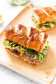 two sandwiches are sitting on a cutting board