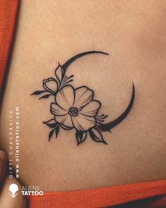 a woman's stomach with a flower and crescent tattoo on the side of her belly