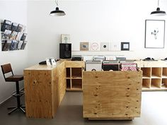 an empty room with several wooden boxes on the floor and two chairs in front of it