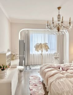 a bed room with a neatly made bed and a chandelier