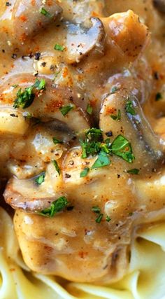 chicken and mushroom gravy over pasta on a white plate