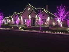 purple christmas lights decorate the front of a house