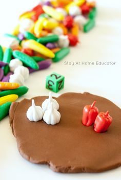 a close up of a cookie on a table with small toys in the shape of vegetables