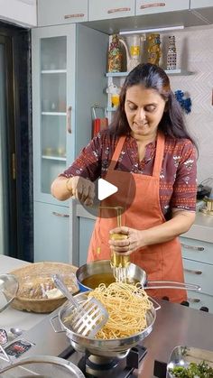 a woman in an orange apron is making pasta