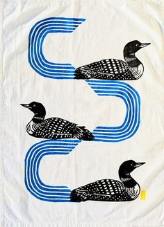 three black and white birds sitting on top of a blue wave in the shape of an oar