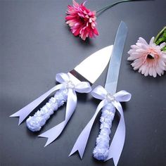 flowers and scissors on a table next to each other with ribbons tied around the blades