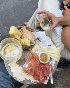 a person sitting at a table with food and wine