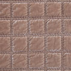 a brown quilted blanket with squares on it