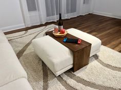 a coffee table with an apple and bottle on it in the middle of a living room