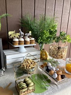 a table topped with lots of desserts and cupcakes