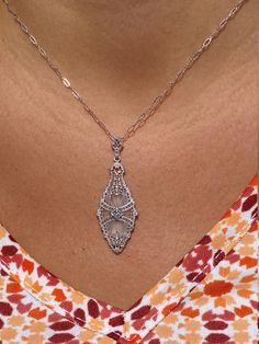 The Toomavara Ladies White Gold Filigree Camphor Glass Necklace set with Diamond. Delicately crafted in white gold, this vintage necklace features intricate filigree designs draped over camphor glass. Complete with an accent diamond, this pendant dangles from a 16 inch white gold chain. The chain can be swapped for another length chain for an additional charge. Each piece has been hand selected and meticulously identified and graded by a Graduate Gemologist who has been awarded a degree by the G Camphor Glass Necklace, White Gold Chain, White Gold Chains, Filigree Design, Gold Filigree, Wedding Necklaces, Wedding Look, Glass Necklace, Wedding Necklace