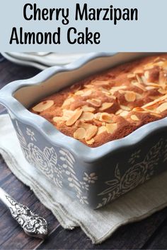 a close up of a cake in a pan with almonds on top and the words cherry marzipan almond cake