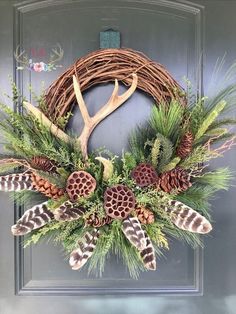 a wreath with antlers, pine cones and feathers