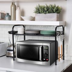 a microwave oven sitting on top of a counter next to plates and utensils