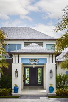 a white house with blue accents and palm trees