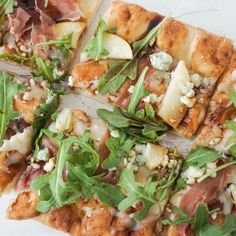 a pizza topped with lots of toppings on top of a white plate and cut into slices