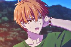 an anime character with red hair and green shirt holding his hand to his ear while looking at the camera