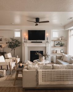 a living room filled with furniture and a flat screen tv mounted on the wall above a fireplace