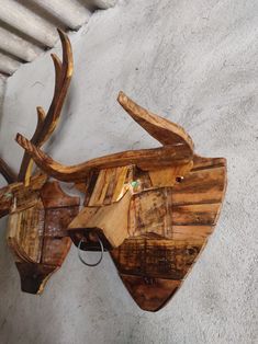 a wooden deer head mounted to the side of a wall