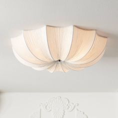 a white ceiling light hanging from the ceiling in a room with an ornate design on it