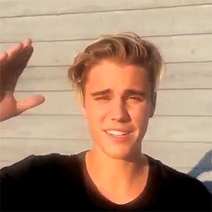 a close up of a person wearing a black t - shirt with his hand in the air