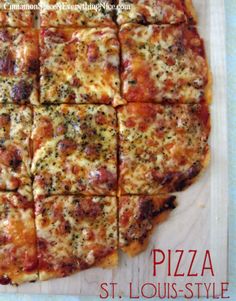 a square shaped pizza sitting on top of a wooden cutting board