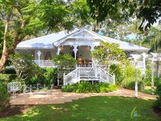 a white house surrounded by greenery and trees