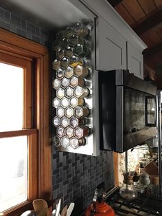 a stove top oven sitting inside of a kitchen next to a wall filled with pots and pans