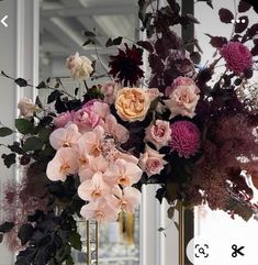 a vase filled with lots of flowers on top of a table