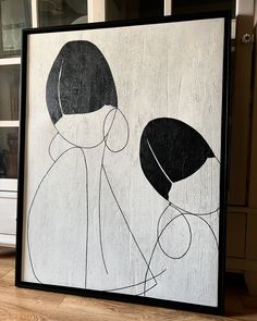 an abstract painting with black and white lines on it's frame, in front of a window