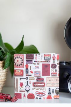 a white table topped with a potted plant next to a wall covered in stickers