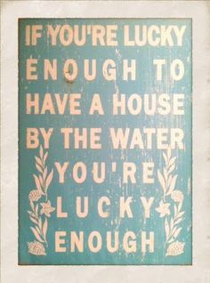 a blue and white sign that says if you're lucky enough to have a house by the water you're lucky enough